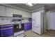 Well-lit kitchen featuring white appliances, ample counter space, and stylish purple lower cabinets at 35070 Smoketree Ln, Dade City, FL 33523