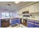 Bright kitchen featuring matching appliances, ample counter space, and stylish blue lower cabinets at 35070 Smoketree Ln, Dade City, FL 33523