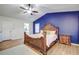 An ornate main bedroom with a ceiling fan, wood floors, blue accent wall and lots of natural light at 35070 Smoketree Ln, Dade City, FL 33523