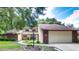 Brick house with attached garage and landscaped front yard at 35070 Smoketree Ln, Dade City, FL 33523