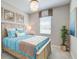 Light and airy bedroom with a wooden bed frame and teal bedding at 7961 Lakes Edge Ln, Port Charlotte, FL 33981