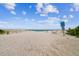 A view of the beach and ocean on a sunny day, with soft sand and clear skies at 221 Howard Dr, Belleair Beach, FL 33786