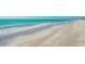 A view of the beach and ocean on a sunny day, with turquoise water and soft, light-colored sand at 221 Howard Dr, Belleair Beach, FL 33786