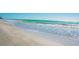 A view of the beach and ocean on a sunny day, featuring turquoise water and soft, light-colored sand at 221 Howard Dr, Belleair Beach, FL 33786