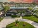 Well-maintained home featuring a lush, green lawn, a circular driveway and mature landscaping at 221 Howard Dr, Belleair Beach, FL 33786
