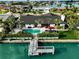 Beautiful waterfront home featuring a private dock and an inviting pool surrounded by lush landscaping at 221 Howard Dr, Belleair Beach, FL 33786