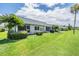 Backyard of condo with lush green grass and partial golf course view at 3332 Scorecard Dr, New Port Richey, FL 34655