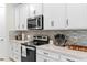 Modern kitchen featuring stainless steel appliances, white cabinetry, and neutral backsplash at 6248 Bradford Woods Dr, Zephyrhills, FL 33542