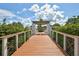 Wooden footbridge with white railings leading to a pergola at 10906 Holly Cone Dr, Riverview, FL 33569