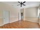 Well-lit bedroom featuring wood-look floors and access to hallway at 10906 Holly Cone Dr, Riverview, FL 33569