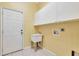 Bright laundry room with utility sink, cabinets, and exterior access at 10906 Holly Cone Dr, Riverview, FL 33569