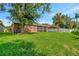 Back exterior of house showcasing a large yard and landscaping at 10906 Holly Cone Dr, Riverview, FL 33569