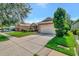 Single-story home on a tree-lined street with a two-car garage at 10906 Holly Cone Dr, Riverview, FL 33569