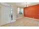 Dining room with orange accent wall, tile flooring, and chandelier at 10906 Holly Cone Dr, Riverview, FL 33569