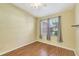 Simple bedroom with hardwood floors, window with blinds and ceiling fan at 10906 Holly Cone Dr, Riverview, FL 33569