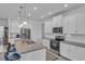 Modern kitchen boasts white cabinets, granite countertops, and stainless steel appliances at 13333 Gershwin Ln, Port Charlotte, FL 33981