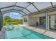Inviting pool area with screened enclosure, lounge chairs, and spacious patio at 13333 Gershwin Ln, Port Charlotte, FL 33981