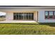 Covered patio with sliding glass doors and grassy yard at 10324 Longmeadow Ave, Parrish, FL 34219