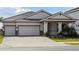 Charming single-story home featuring a spacious three-car garage and well-manicured landscaping at 10324 Longmeadow Ave, Parrish, FL 34219