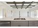 Kitchen island with sink, modern faucet, and white quartz countertop at 10324 Longmeadow Ave, Parrish, FL 34219