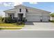 Beautiful home showcasing a well-manicured lawn, stone accents, and a spacious three-car garage at 10426 Longmeadow Ave, Parrish, FL 34219