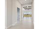 Bright hallway with wood-look tile floors and exposed wooden beams at 10426 Longmeadow Ave, Parrish, FL 34219