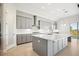 Modern kitchen features gray cabinetry, white quartz countertops, and a large island at 10426 Longmeadow Ave, Parrish, FL 34219