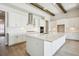 Modern kitchen with white cabinets, a large island, and stainless steel appliances at 10422 Longmeadow Ave, Parrish, FL 34219
