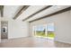 Bright dining room with hardwood floors, exposed wooden beams, and sliding glass doors leading to the backyard at 10422 Longmeadow Ave, Parrish, FL 34219
