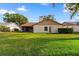 The backyard with well-maintained lawn and mature trees, creating a serene outdoor space at 2618 Crestfield Dr, Valrico, FL 33596