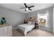 Bedroom featuring wood floors, a ceiling fan, and ample natural light from the large window at 2618 Crestfield Dr, Valrico, FL 33596