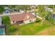 Aerial view of the home's backyard features a brick patio, lush green lawn, mature trees, and a screened porch at 2618 Crestfield Dr, Valrico, FL 33596