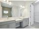 Double vanity bathroom with gray cabinets and a walk-in shower at 13142 Homestead Ln, Parrish, FL 34219