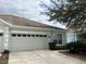 Front view of house with two-car garage at 7443 Surrey Wood Ln, Apollo Beach, FL 33572