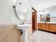 Elegant bathroom with pedestal sink, double vanity, and tiled floors at 6622 Watson Rd, Riverview, FL 33578