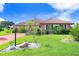 Brick home with red tile roof, landscaping, and driveway at 1826 Wolf Laurel Dr, Sun City Center, FL 33573