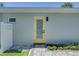 Charming exterior view featuring a light blue exterior wall, a yellow back door, and beautiful landscaping at 120 Chesapeake Ave, Tampa, FL 33606