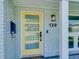 A bright yellow front door with four glass panels and a modern black handle stands out at 120 Chesapeake Ave, Tampa, FL 33606
