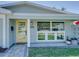 Close-up of the front door with a yellow frame, glass panels, house number, and white trim at 120 Chesapeake Ave, Tampa, FL 33606