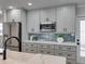 Modern kitchen with stainless steel appliances, a stylish backsplash, and sleek gray cabinetry at 120 Chesapeake Ave, Tampa, FL 33606