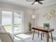 Bright office space with backyard access, modern ceiling fan, wood desk, and decorative gold wall decor at 120 Chesapeake Ave, Tampa, FL 33606