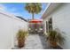 Private patio with red umbrella, bistro set, and patterned wall at 120 Chesapeake Ave, Tampa, FL 33606