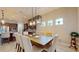 Bright dining room with large wooden table and modern light fixtures at 11411 Drifting Leaf Dr, Riverview, FL 33579