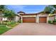 Two-story house with stone facade and three-car garage at 11411 Drifting Leaf Dr, Riverview, FL 33579