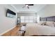 Spacious main bedroom with king-size bed, large TV and hardwood floors at 11411 Drifting Leaf Dr, Riverview, FL 33579