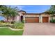 Two-story house with stone facade and three-car garage at 11411 Drifting Leaf Dr, Riverview, FL 33579
