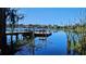 Scenic view of the lake featuring a wooden dock, seating, and clear blue skies at 1817 Hammocks Ave # 1817, Lutz, FL 33549
