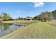 Expansive backyard view with a pond, green lawn, white fence, and a glimpse of the house at 19300 Lonesome Pine Dr, Land O Lakes, FL 34638