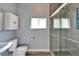Bathroom features tiled shower with glass door, toilet, window, and wooden-look tile floors at 19300 Lonesome Pine Dr, Land O Lakes, FL 34638