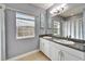 Bright bathroom featuring a double sink vanity with granite countertops and a large mirror at 19300 Lonesome Pine Dr, Land O Lakes, FL 34638